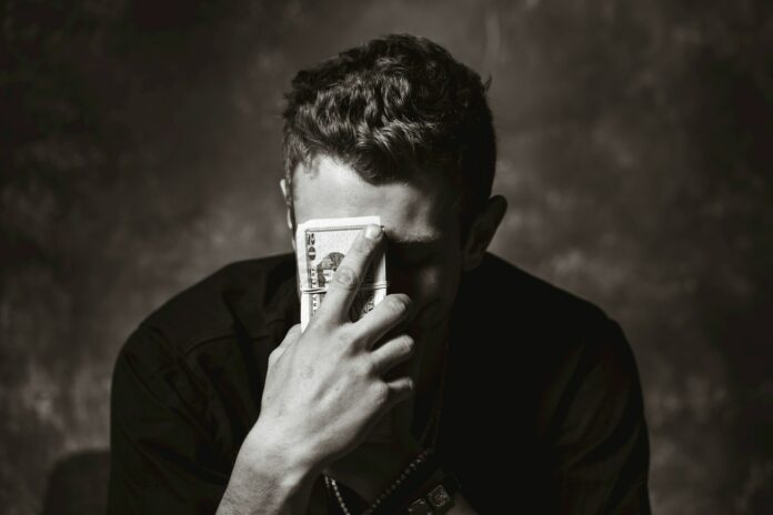 Photo by Travis Essinger man holding banknote