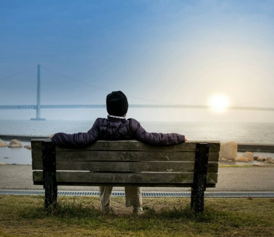 여름철 야외 운동 시 주의사항 person sitting on bench facing suspension bridge