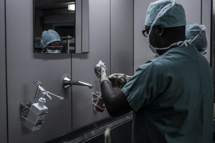 Photo by Piron Guillaume man wearing surgical suit near mirror
