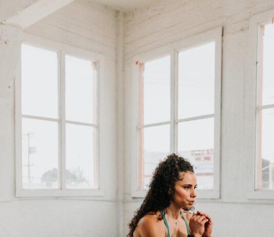 비 오는 날의 실내 운동: 홈 트레이닝으로 건강 챙기기 a woman squatting on the floor in a gym