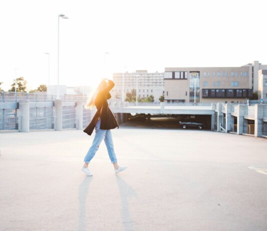 일상에서 쉽게 실천할 수 있는 피로 회복 방법 woman walking on road near building at daytime