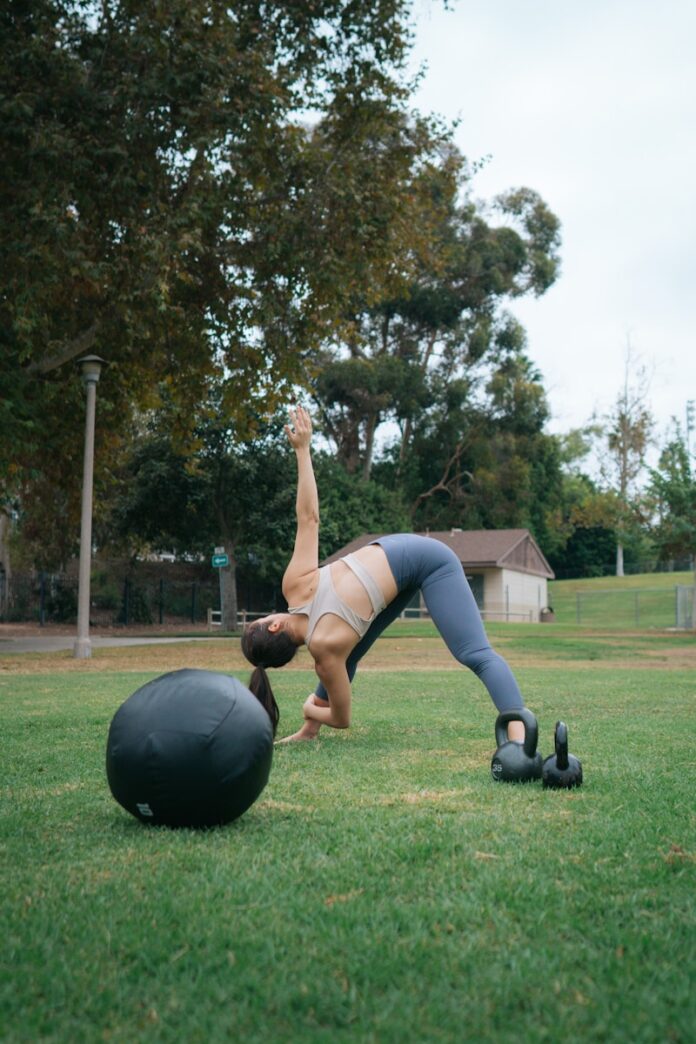 Photo by Dex Ezekiel woman in white tank top and gray leggings doing push up on black exercise ball on near near near near