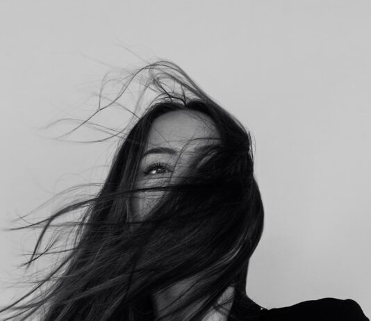 건강한 모발을 위한 생활 습관과 관리법 grayscale photography of woman wearing long-sleeved shirt