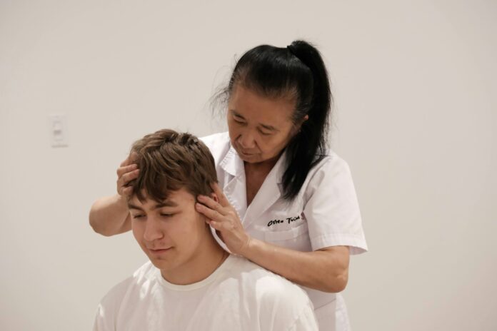 Photo by Osteo Tuina A man getting his hair cut by a woman