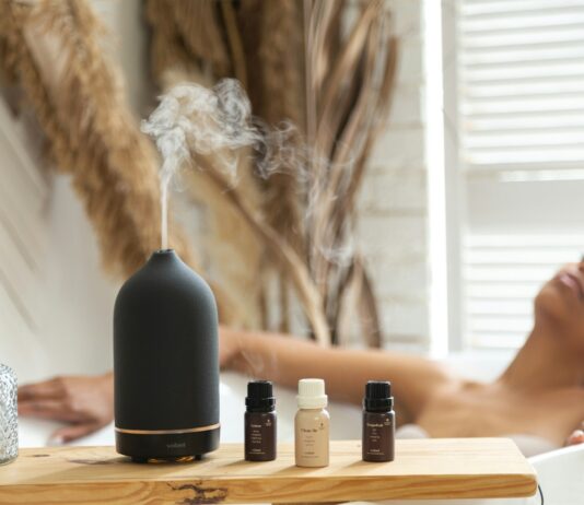 현대인의 일상에 스며드는 대체요법, 내게 맞는 실천 루틴 찾기 a woman laying in a bathtub next to a bottle of essential oils