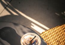 “마음을 지키는 작은 습관, 일상 속 스트레스 관리법 주목” Iced coffee on a table with dappled sunlight