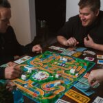 “뇌 건강 지키기, 생활 속 작은 실천에서 시작된다” two men playing a game of monopoly on a table